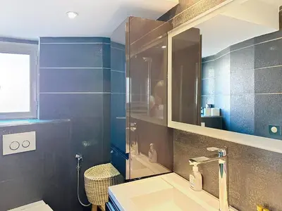 a bathroom with a sink and a shower with a mirror at Stylish 1-bedroom apartment with sea view on La Croisette in Cannes