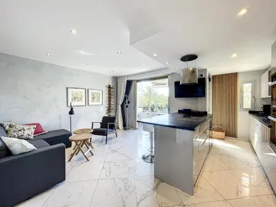 a kitchen and living room with a couch and a table at Stylish 1-bedroom apartment with sea view on La Croisette in Cannes