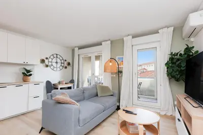 a living room with a couch and a table at Immogroom - Warm T2 - AC - Wifi - Comfort in Cannes