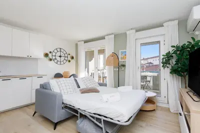 a living room with a bed and a kitchen at Immogroom - Warm T2 - AC - Wifi - Comfort in Cannes