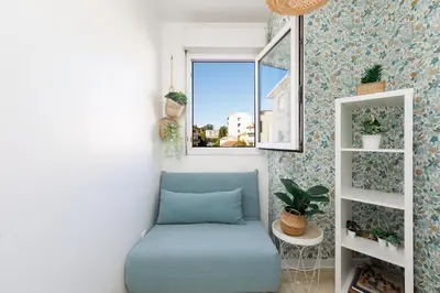 a blue couch in a room with a window at Immogroom - Warm T2 - AC - Wifi - Comfort in Cannes