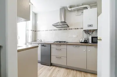 a kitchen with white cabinets and a stove top oven at L'Escapade Cannoise Forville in Cannes