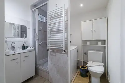 a white bathroom with a shower and a toilet at L'Escapade Cannoise Forville in Cannes