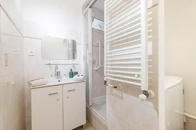 a white bathroom with a sink and a shower at L'Escapade Cannoise Forville in Cannes