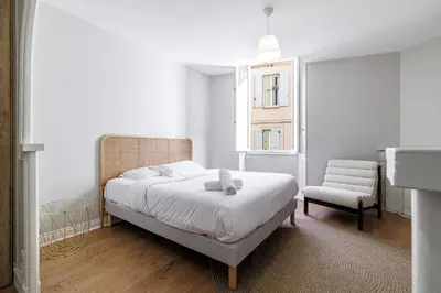a bedroom with a bed and a chair at L'Escapade Cannoise Forville in Cannes