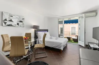 a hotel room with a bed and a table and chairs at Luxury Studio YourHostHelper in Cannes