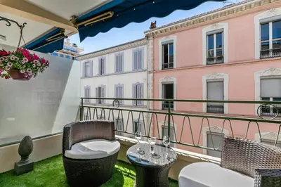 a balcony with wicker chairs and a table at Luxury Studio YourHostHelper in Cannes