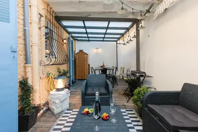 a patio with chairs and a table with a bottle of wine at Perrissol YourHostHelper in Cannes