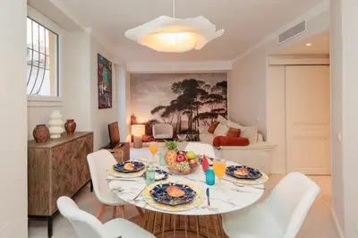 a dining room with a table and white chairs at Perrissol YourHostHelper in Cannes
