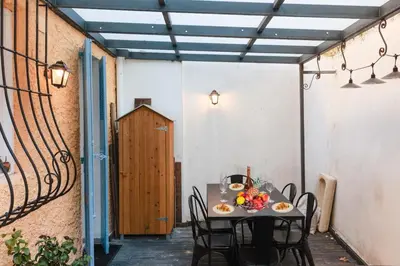 a patio with a table and chairs and a wooden door at Perrissol YourHostHelper in Cannes