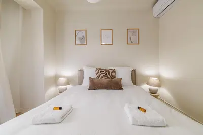 a white bedroom with a large white bed with two pillows at Cannes banana apartment in Cannes