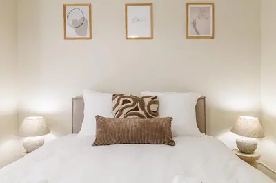 a white bed with white pillows and three pictures on the wall at Cannes banana apartment in Cannes