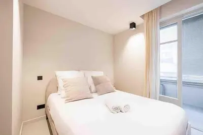 a white bed in a room with a window at Pasteur Luxury apartment la Croisette in Cannes