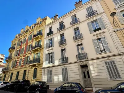 a large building with cars parked in front of it at Villa Mimosa - Cannes in Cannes