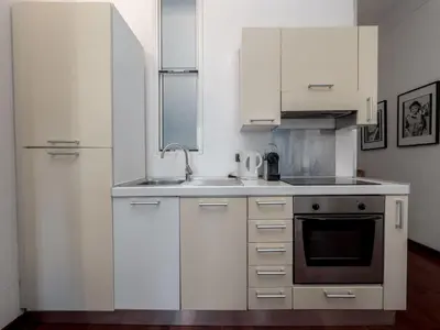 a white kitchen with a sink and a refrigerator at Apartment rue des Serbes by Interhome in Cannes