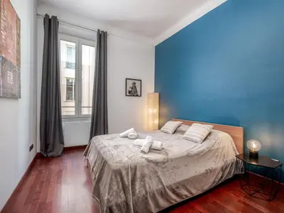 a bedroom with a large bed with a blue wall at Apartment rue des Serbes by Interhome in Cannes