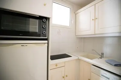 a kitchen with white cabinets and a microwave at One bedroom apartment with beautiful sea view in Cannes