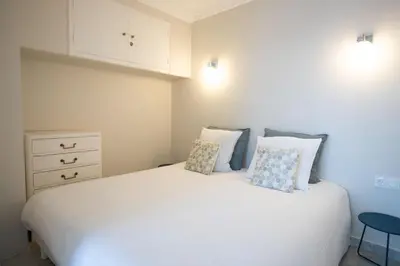 a bedroom with a white bed with two pillows at One bedroom apartment with beautiful sea view in Cannes