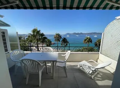 a table and chairs on a balcony with a view of the ocean at One bedroom apartment with beautiful sea view in Cannes