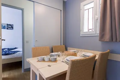 a dining room with a table and chairs and a window at Cosy Francia - Terrasse, Piscine, parking, clim in Cannes