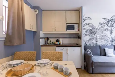 a living room with a table and a couch at Cosy Francia - Terrasse, Piscine, parking, clim in Cannes