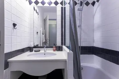 a white bathroom with a sink and a tub at Cosy Francia - Terrasse, Piscine, parking, clim in Cannes