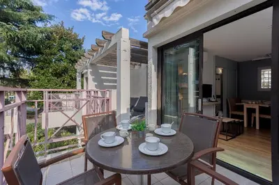 a table on the balcony of a house at Cosy Francia - Terrasse, Piscine, parking, clim in Cannes