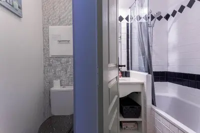 a bathroom with a toilet and a sink and a tub at Cosy Francia - Terrasse, Piscine, parking, clim in Cannes