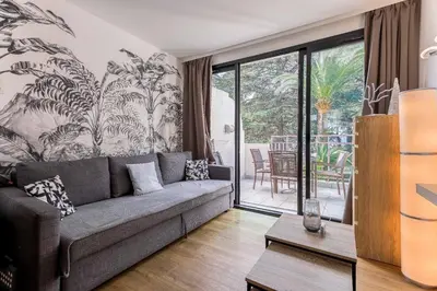 a living room with a couch and a large window at Cosy Francia - Terrasse, Piscine, parking, clim in Cannes