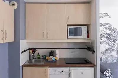 a kitchen with a sink and a microwave at Cosy Francia - Terrasse, Piscine, parking, clim in Cannes