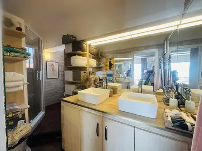 a bathroom with two sinks and a large mirror at Appartement face mer LES PRINCES in Cannes