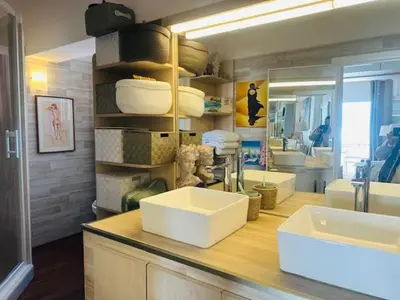 a bathroom counter with two sinks and a mirror at Appartement face mer LES PRINCES in Cannes