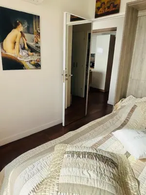 a bedroom with a bed and a painting on the wall at Appartement face mer LES PRINCES in Cannes