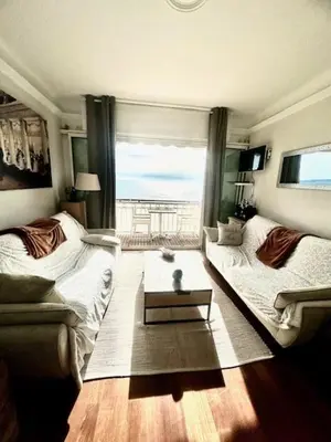 a living room with a couch and a table at Appartement face mer LES PRINCES in Cannes