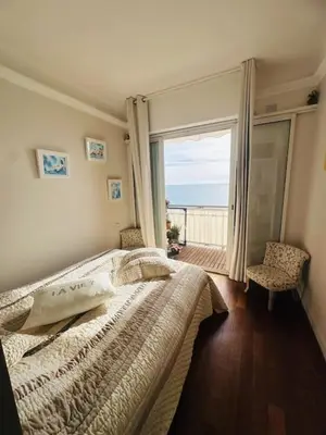 a bedroom with a bed with a view of the ocean at Appartement face mer LES PRINCES in Cannes