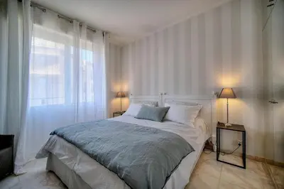 a bedroom with a bed and a large window at REF 1482 - Cannes Back Croisette - Apartment for rent in Cannes