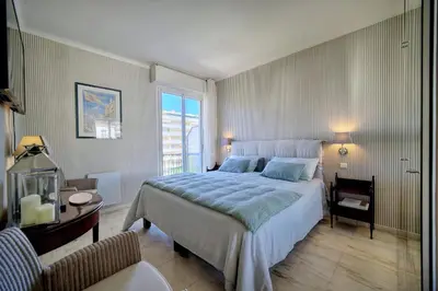 a bedroom with a large bed and a window at REF 1482 - Cannes Back Croisette - Apartment for rent in Cannes