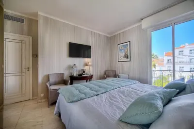 a bedroom with a large bed and a window at REF 1482 - Cannes Back Croisette - Apartment for rent in Cannes