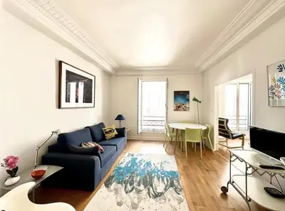 a living room with a blue couch and a table at Charming apartment steps away from La Croisette and Palais de Festival in Cannes