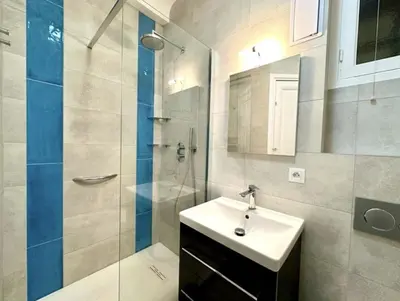 a bathroom with a sink and a glass shower at Charming apartment steps away from La Croisette and Palais de Festival in Cannes