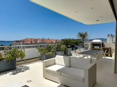 a kitchen with a bar and chairs on a balcony at Penthouse 2-Bedroom apartment with 360º views and parking in Cannes