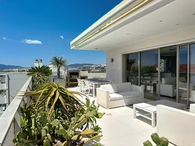a balcony with a white couch and a table at Penthouse 2-Bedroom apartment with 360º views and parking in Cannes