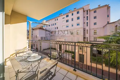 a balcony with a table and chairs and a building at 2 pièces - Très proche Croisette et Palais des Festivals in Cannes