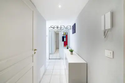 a hallway with white walls and a white tile floor at 2 pièces - Très proche Croisette et Palais des Festivals in Cannes