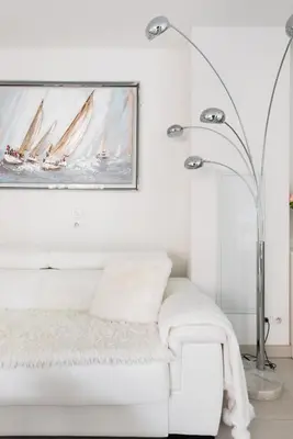 a white living room with a white couch and a painting at Luxueux appartement proche de la Croisette avec grande terrasse aménagée in Cannes