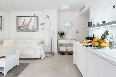 a white kitchen and living room with a white couch at Luxueux appartement proche de la Croisette avec grande terrasse aménagée in Cannes