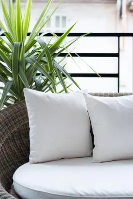 two pillows sitting on a wicker chair with a plant at Luxueux appartement proche de la Croisette avec grande terrasse aménagée in Cannes