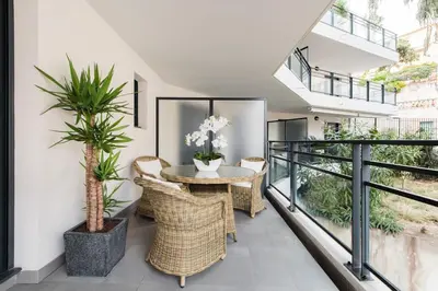 a balcony with a table and wicker chairs at Luxueux appartement proche de la Croisette avec grande terrasse aménagée in Cannes