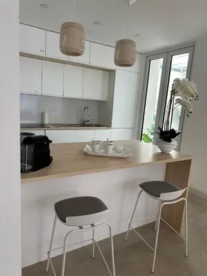 a kitchen with two chairs and a counter with a counter top at Maison 4pièces -Haut Standing CANNES in Cannes