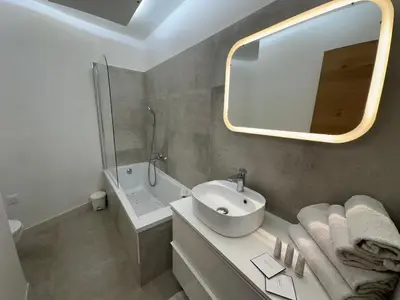 a white bathroom with a sink and a mirror at Maison 4pièces -Haut Standing CANNES in Cannes